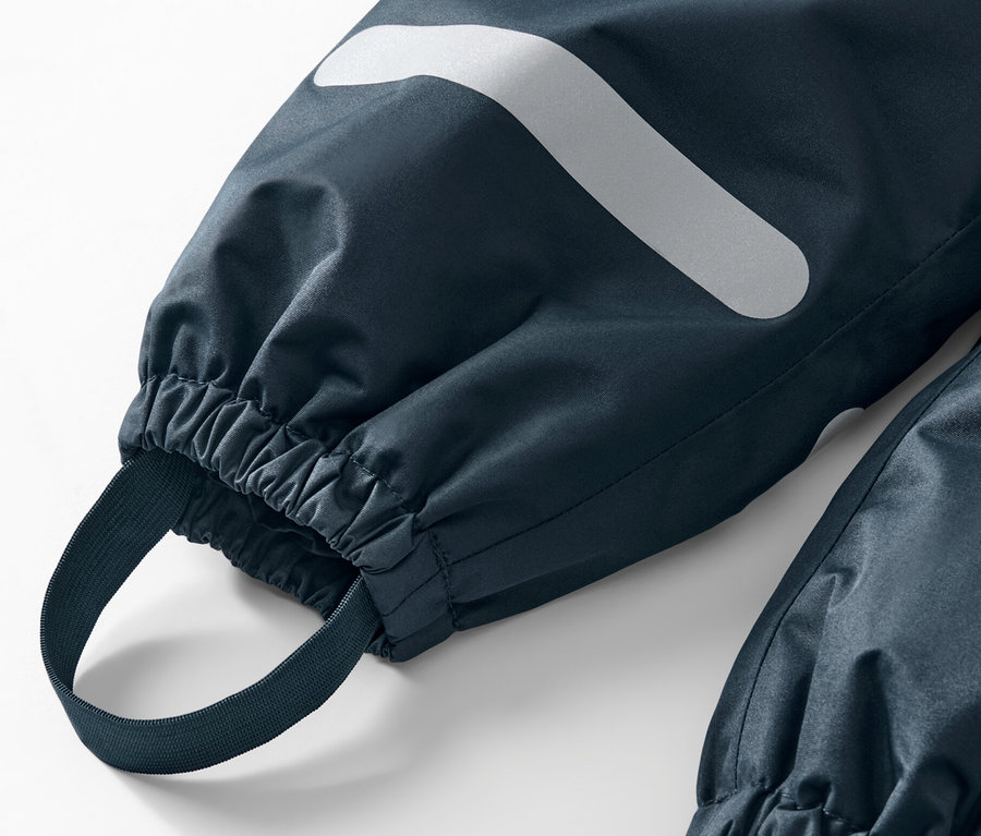 Zbliżenie na spodnie przeciwdeszczowe z odblaskiem i gumką.