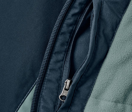 Zbliżenie na kieszeń na zamek w dziecięcej kurtce turystyczno-snowboardowej.