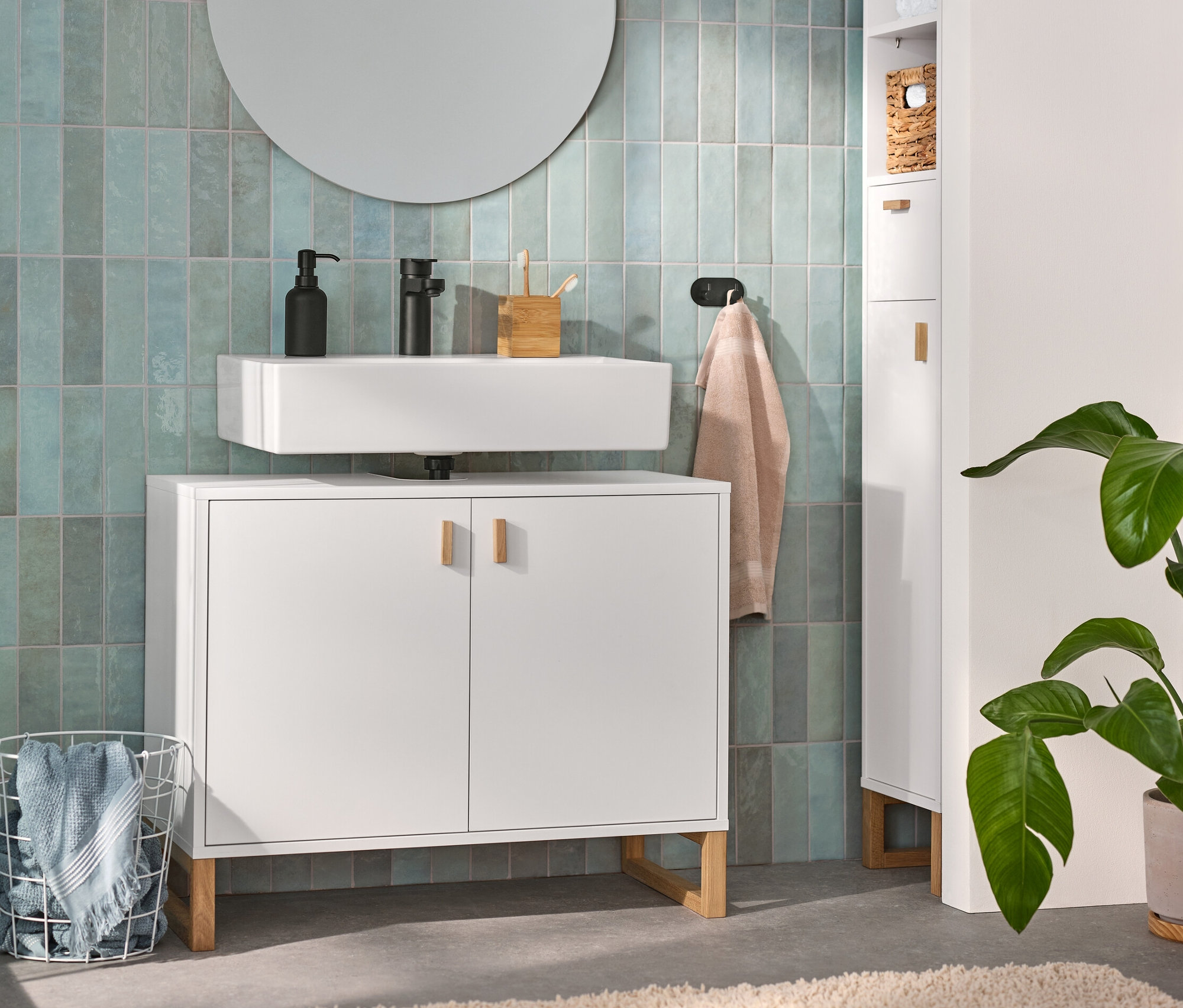 Łazienka z wysoką szafką łazienkową, lustrem z półkami i szafką pod umywalkę.