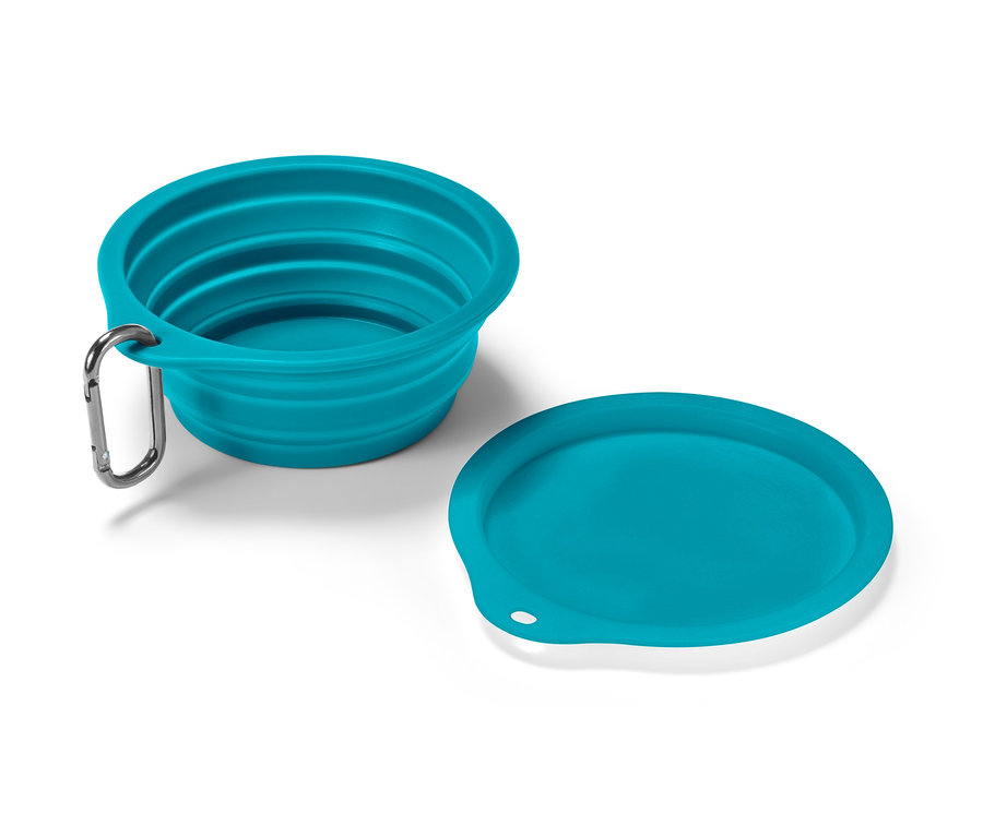Turkusowa składana miska na karmę i pokrywka leżą na białej powierzchni.