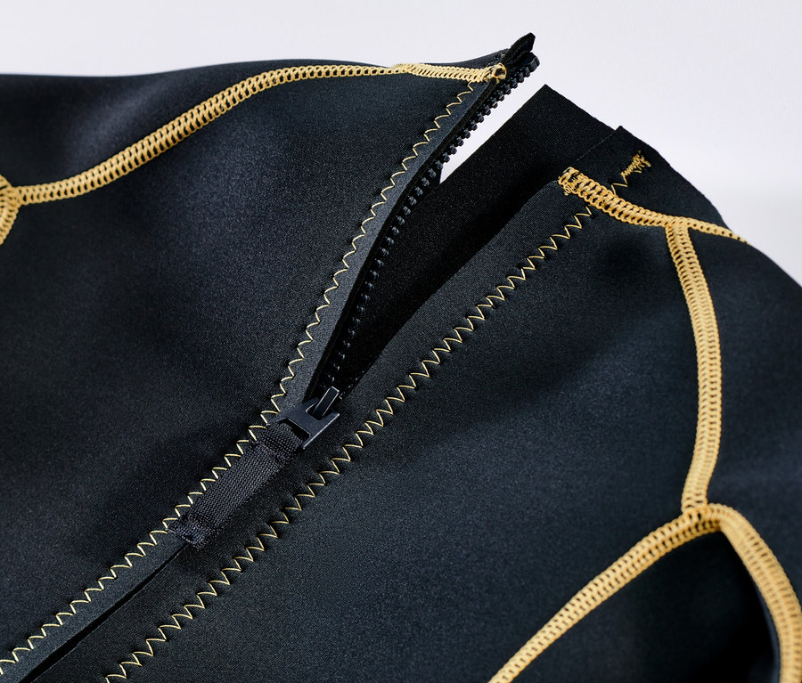 Zbliżenie na dziecięcy kombinezon piankowy z rozpiętym zamkiem i żółtymi obszyciami.