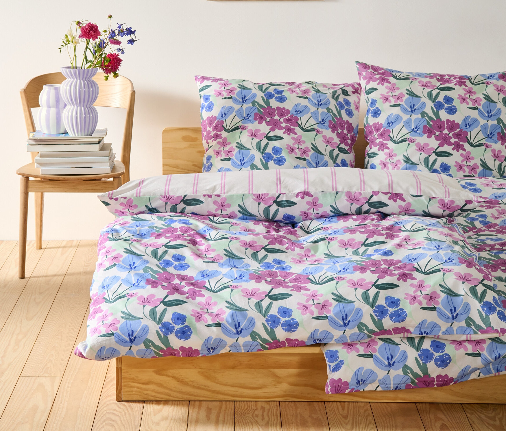 Biała pościel z bawełny renforcé w kwiaty na drewnianym łóżku.