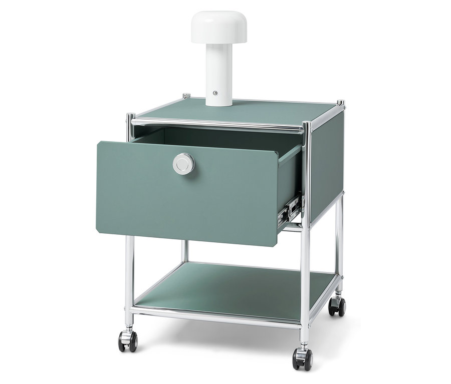 Zielony stolik nocny z otwartą szufladą i białą lampą na górze.