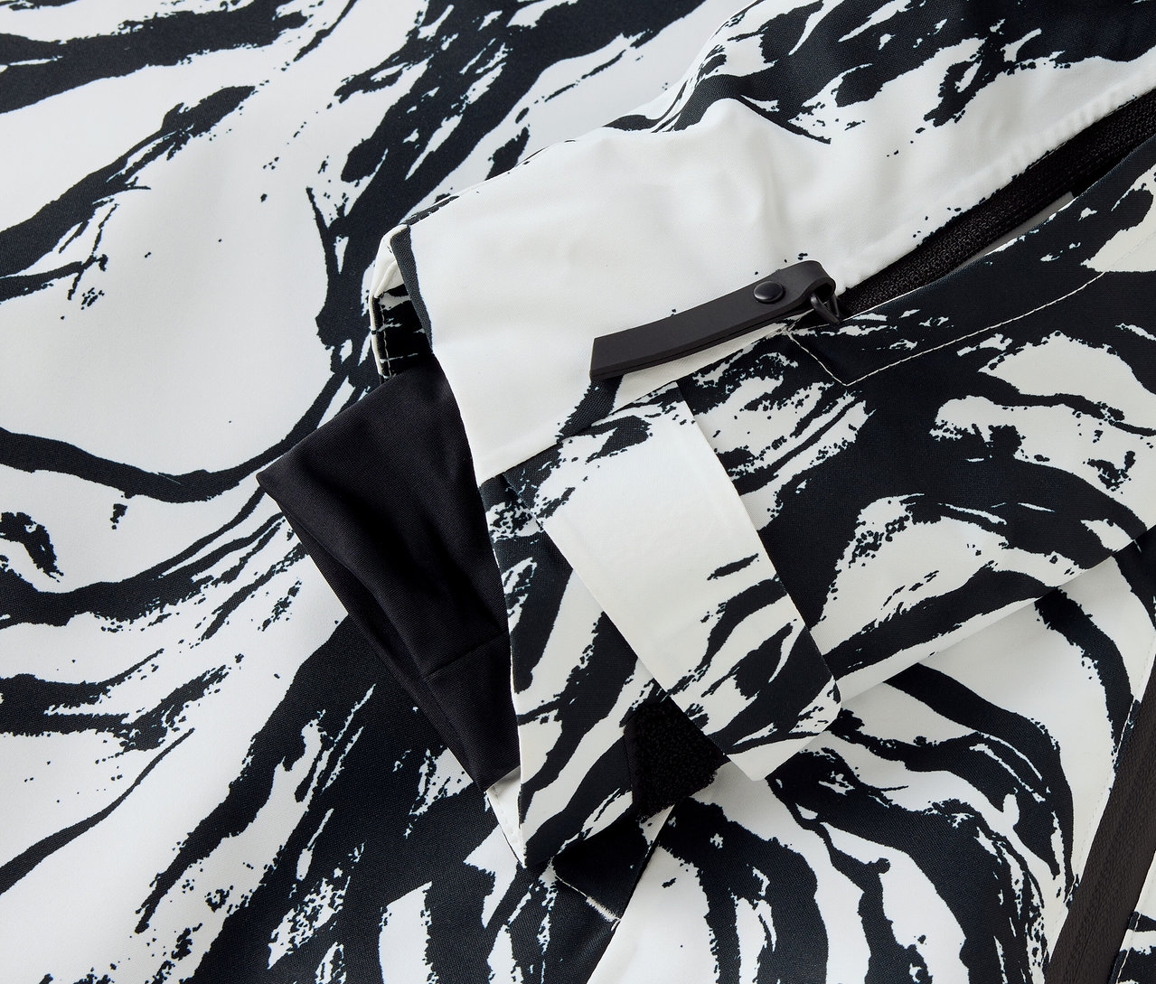 Detal kurtki we wzór zebry w kolorze białym i czarnym, widoczny rękaw i zamek błyskawiczny.