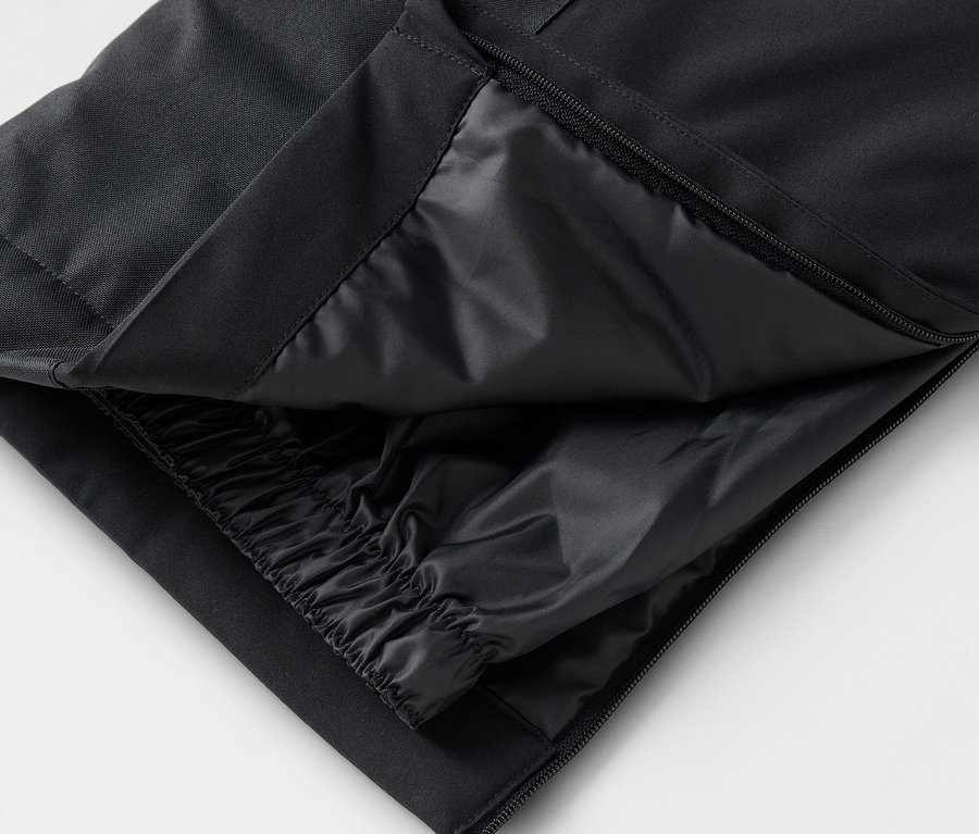 Szczegół czarnych spodni z rozpiętym zamkiem i wewnętrzną warstwą.