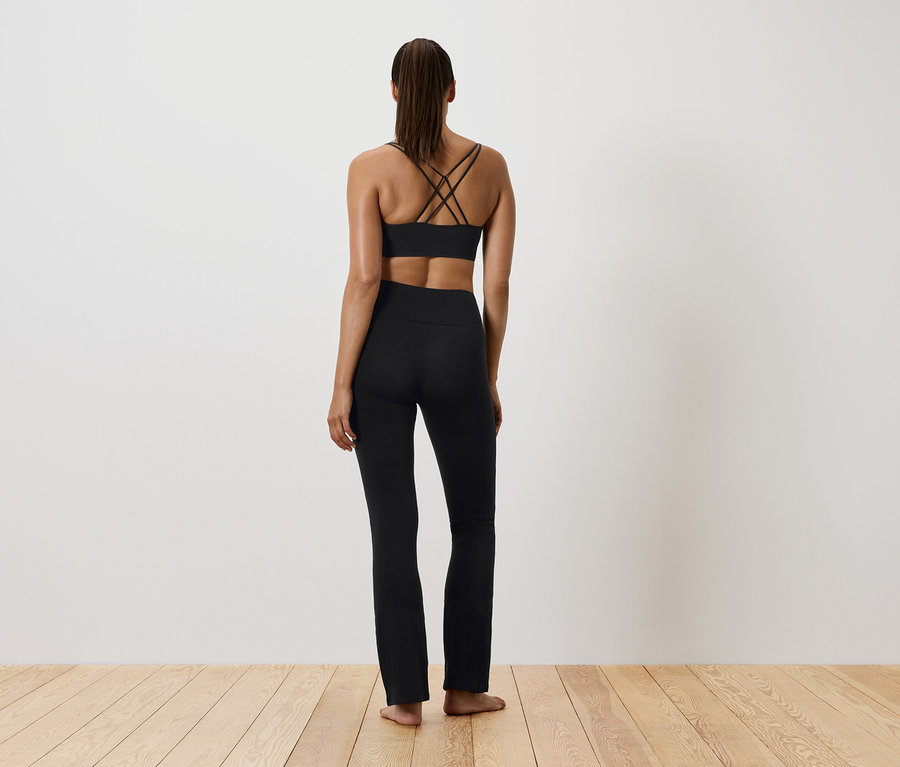 Kobieta w czarnym stroju sportowym, widziana od tyłu.