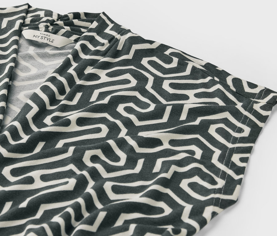 Zbliżenie na zieloną bluzkę z dekoltem w serek we wzory.