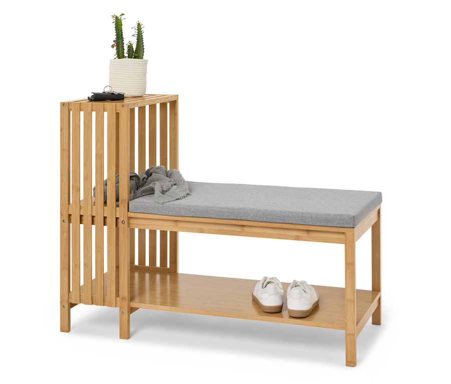 Bambusowy regał na buty z ławką i tapicerowanym siedziskiem, na którym stoi roślina, brelok i szalik.