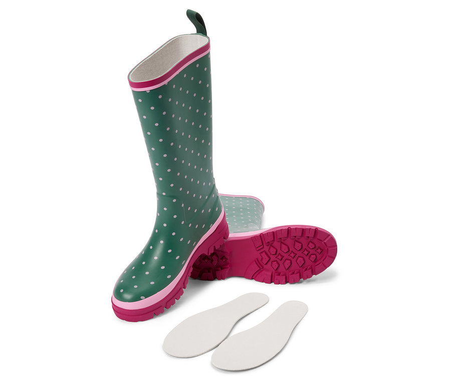Para zielonych kaloszy w białe kropki leży na boku, obok leżą białe wkładki do butów.