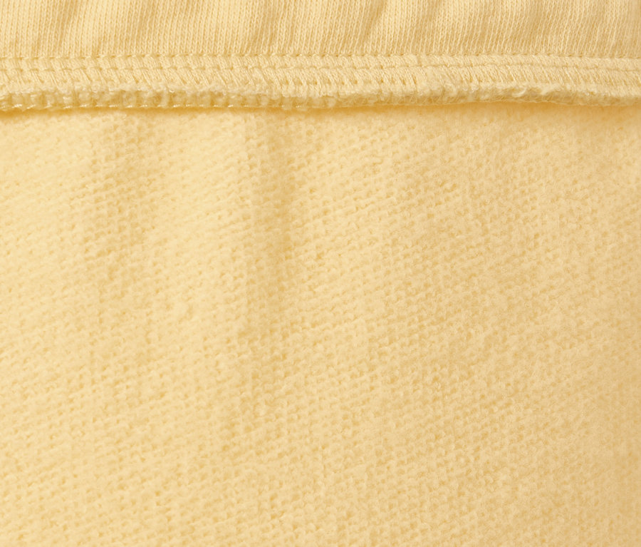 Zbliżenie na żółte spodnie dresowe.