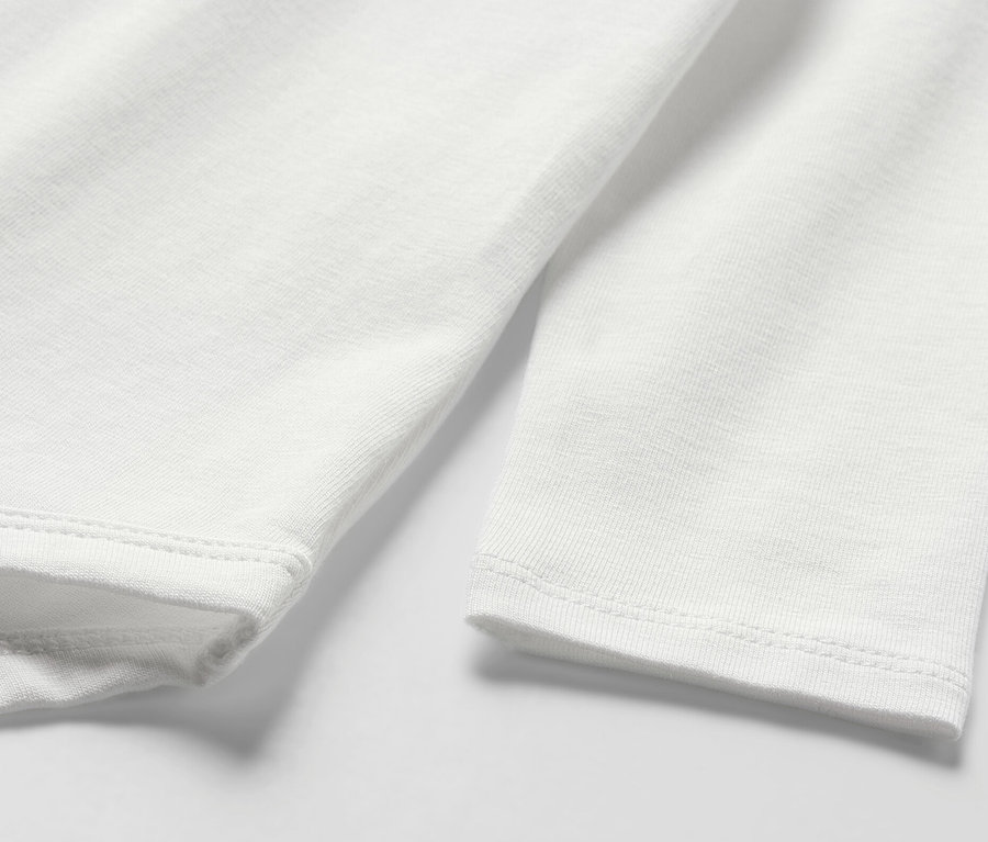 Szczegół białego body niemowlęcego z długim rękawem.