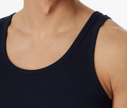 Mężczyzna ma na sobie granatową podkoszulkę trykotową SCHIESSER.