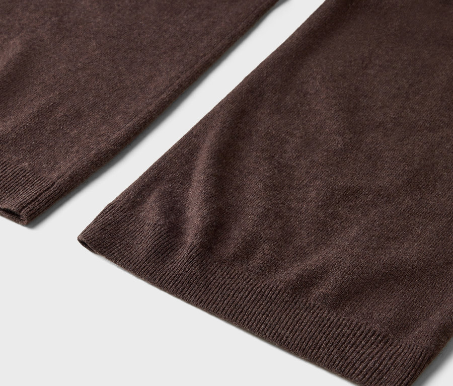 Szczegół brązowych wełnianych spodni z prążkowanym obszyciem.