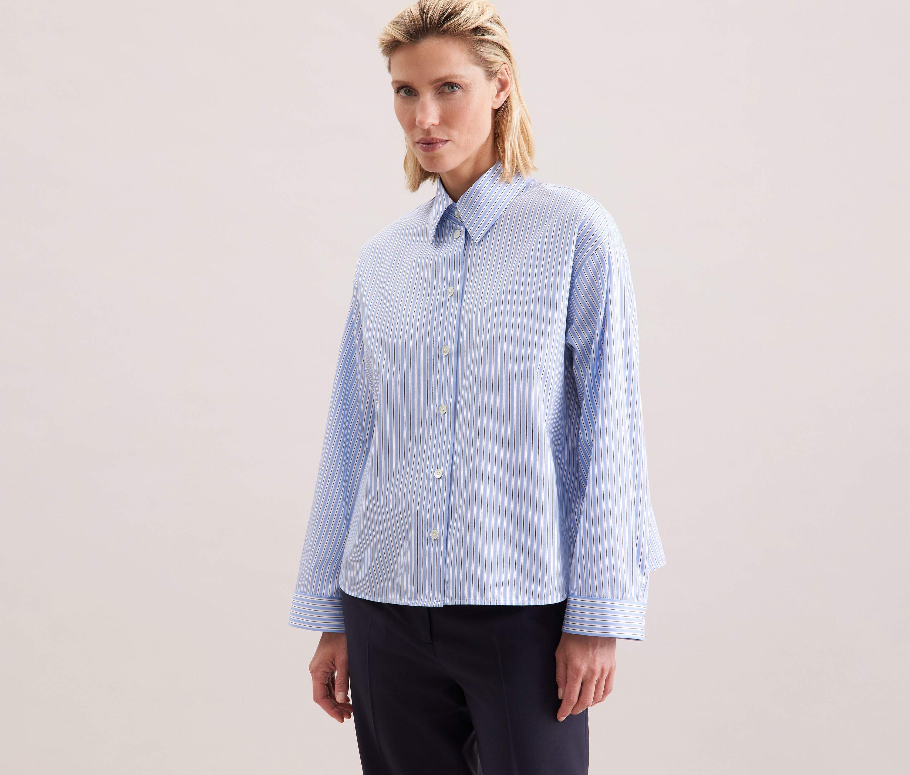 Kobieta ma na sobie koszulę oversize Seidensticker w niebieskie paski.