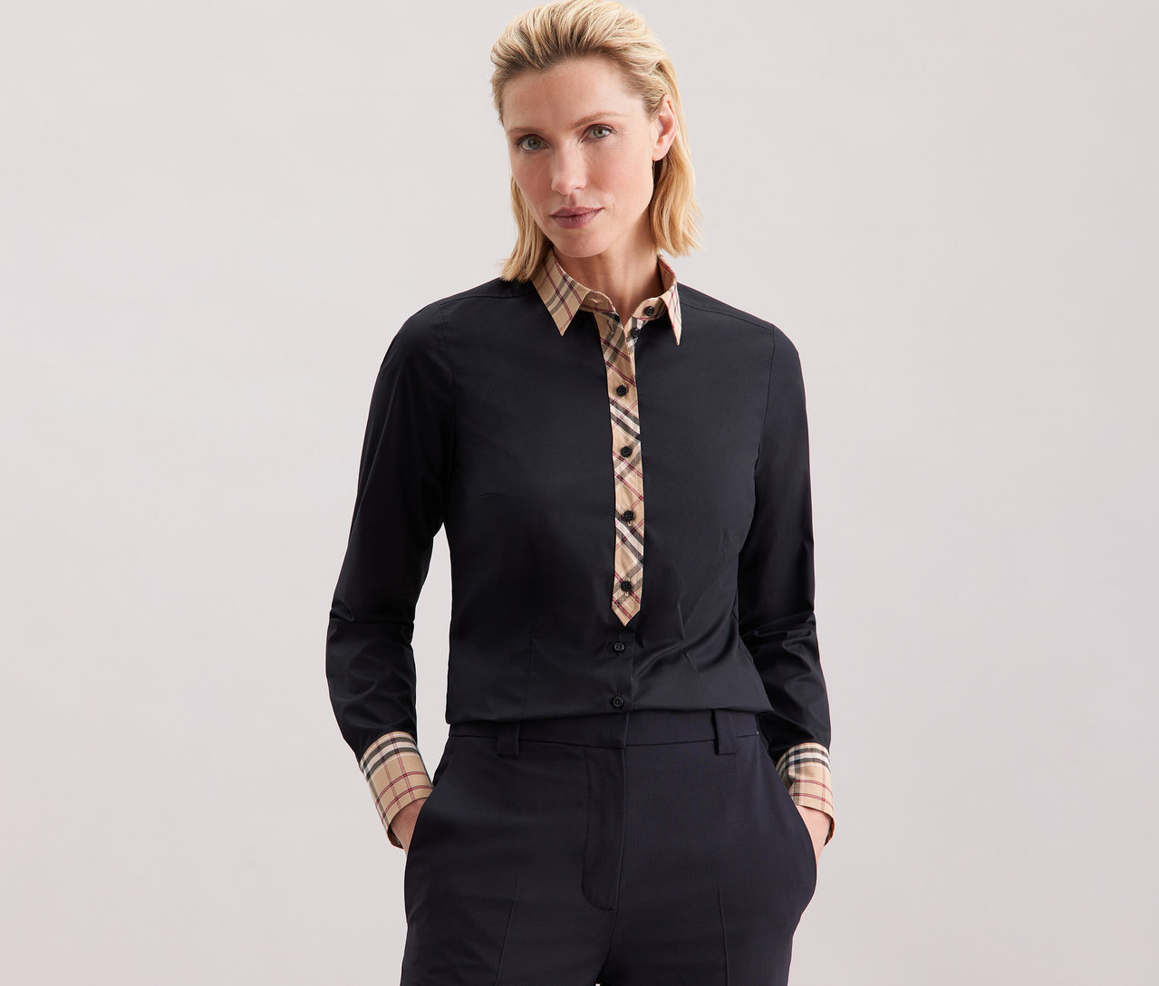 Kobieta ma na sobie popelinową bluzkę Seidensticker z kratkowanymi detalami.