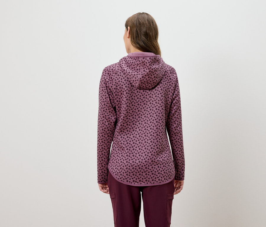 Kobieta w bordowym dresie z kapturem i wzorem zwierzęcym, widziana od tyłu.