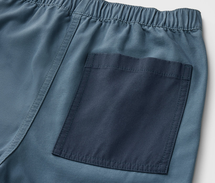 Szczegół szortów z elastycznym pasem i tylną kieszenią.
