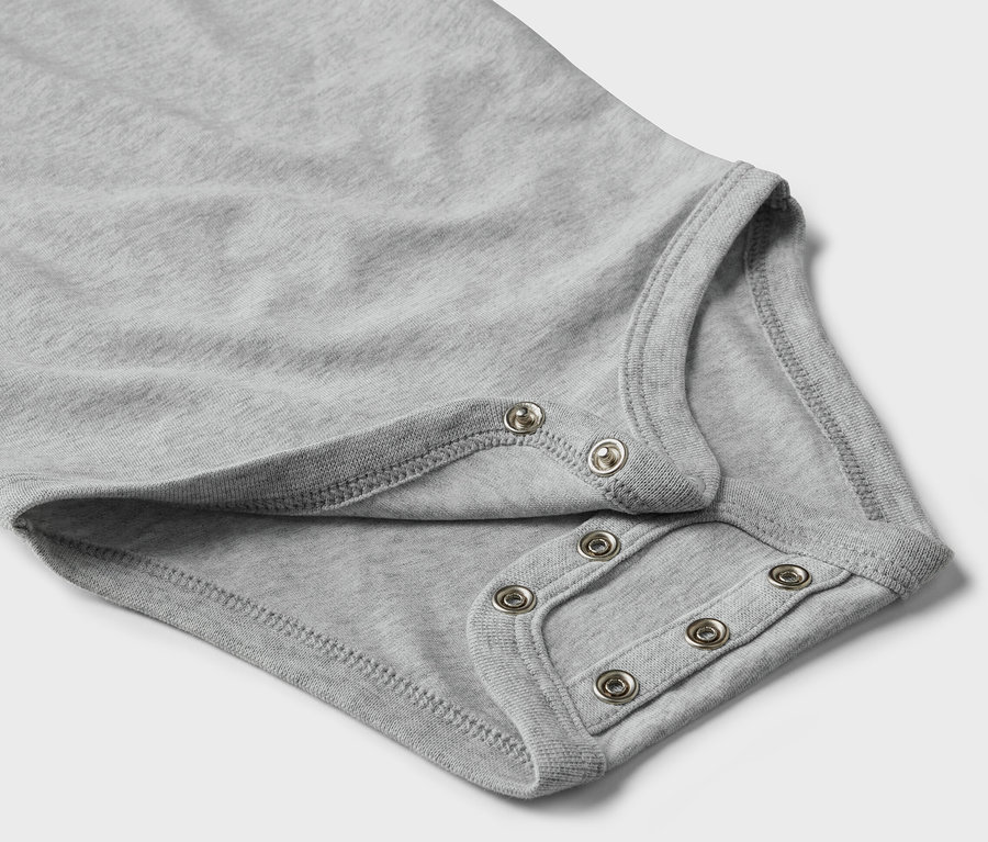 Szczegół szarego body z zatrzaskami dla niemowląt.