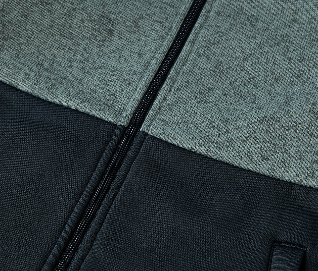 Zbliżenie na kurtkę hybrydową z dzianiny polarowej dla dzieci z zamkiem błyskawicznym.