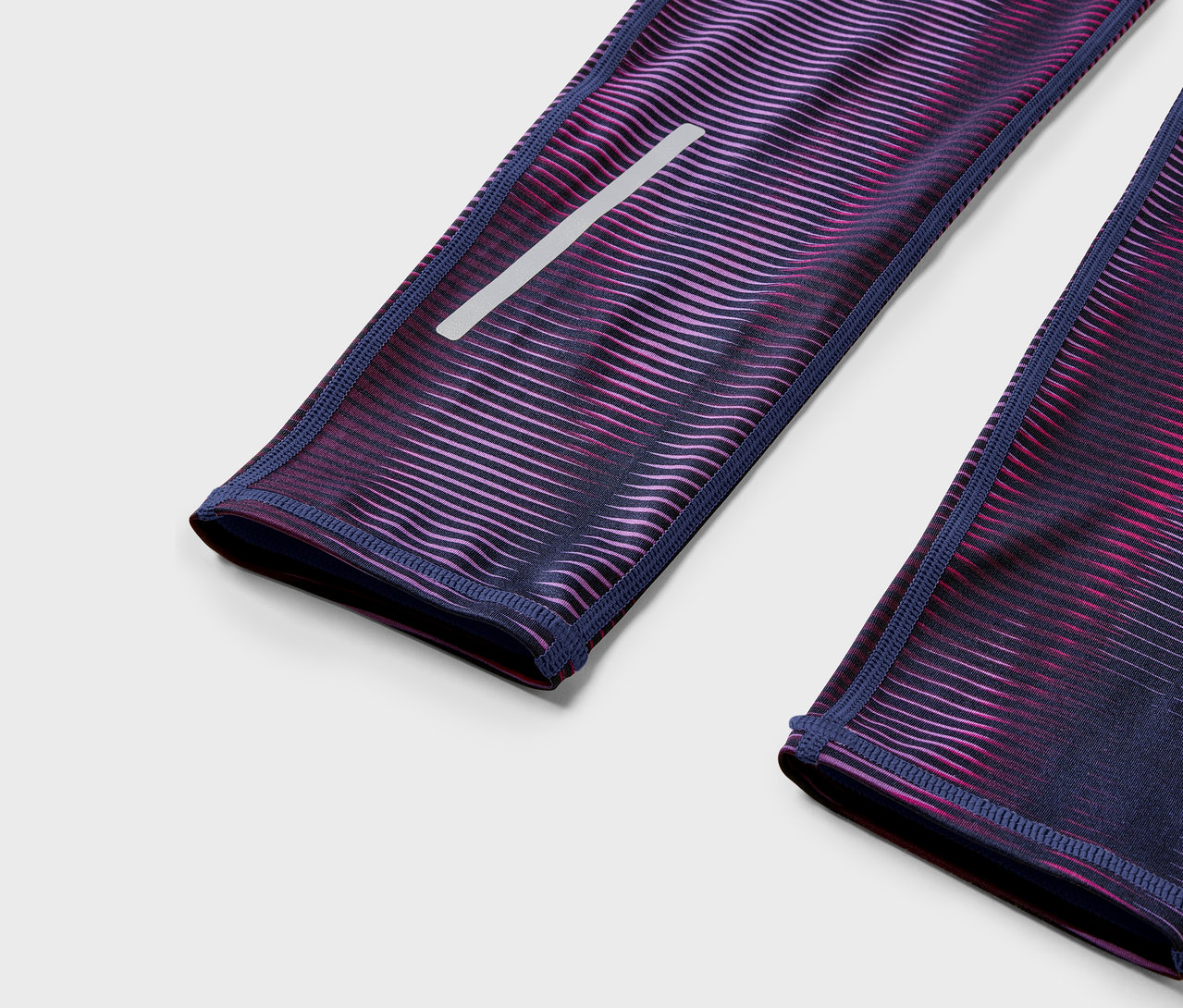 Zbliżenie na fioletowo-różowe legginsy z elementem odblaskowym.