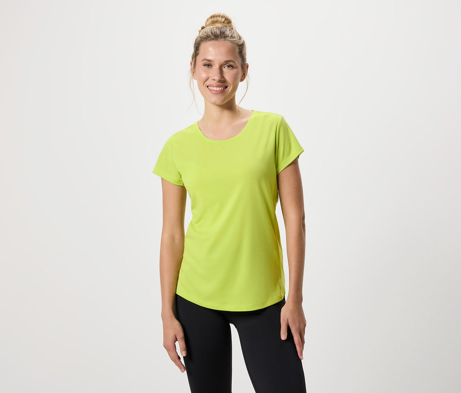 Kobieta ma na sobie jasnozieloną koszulkę i czarne legginsy.