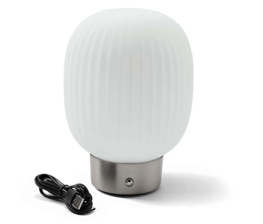 Lampa stołowa LED z akumulatorem i szklanym kloszem stoi obok czarnego kabla ładującego.