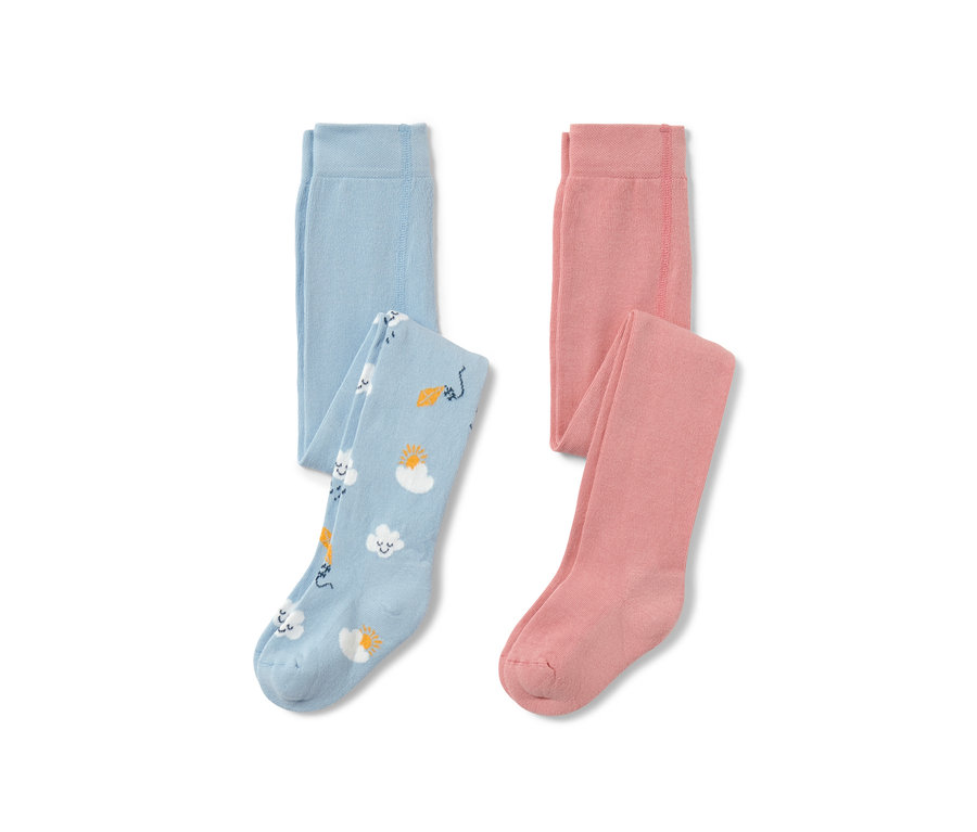 Dwie pary rajstop dziecięcych: jedne jasnoniebieskie we wzory chmur, słońca i latawca, drugie różowe.