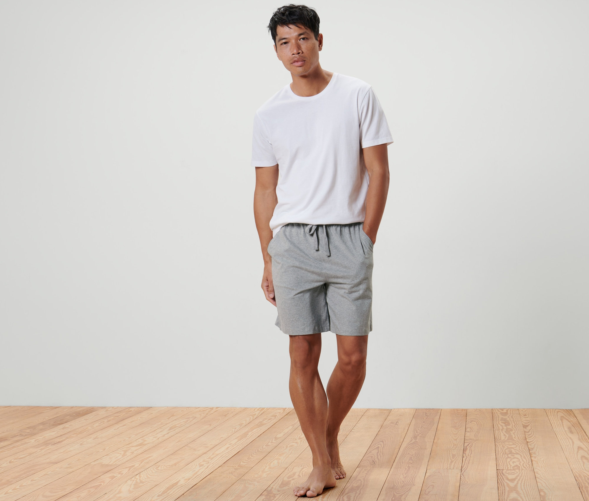 Mężczyzna stoi z rękami w kieszeniach Krótkich spodenek rekreacyjnych.