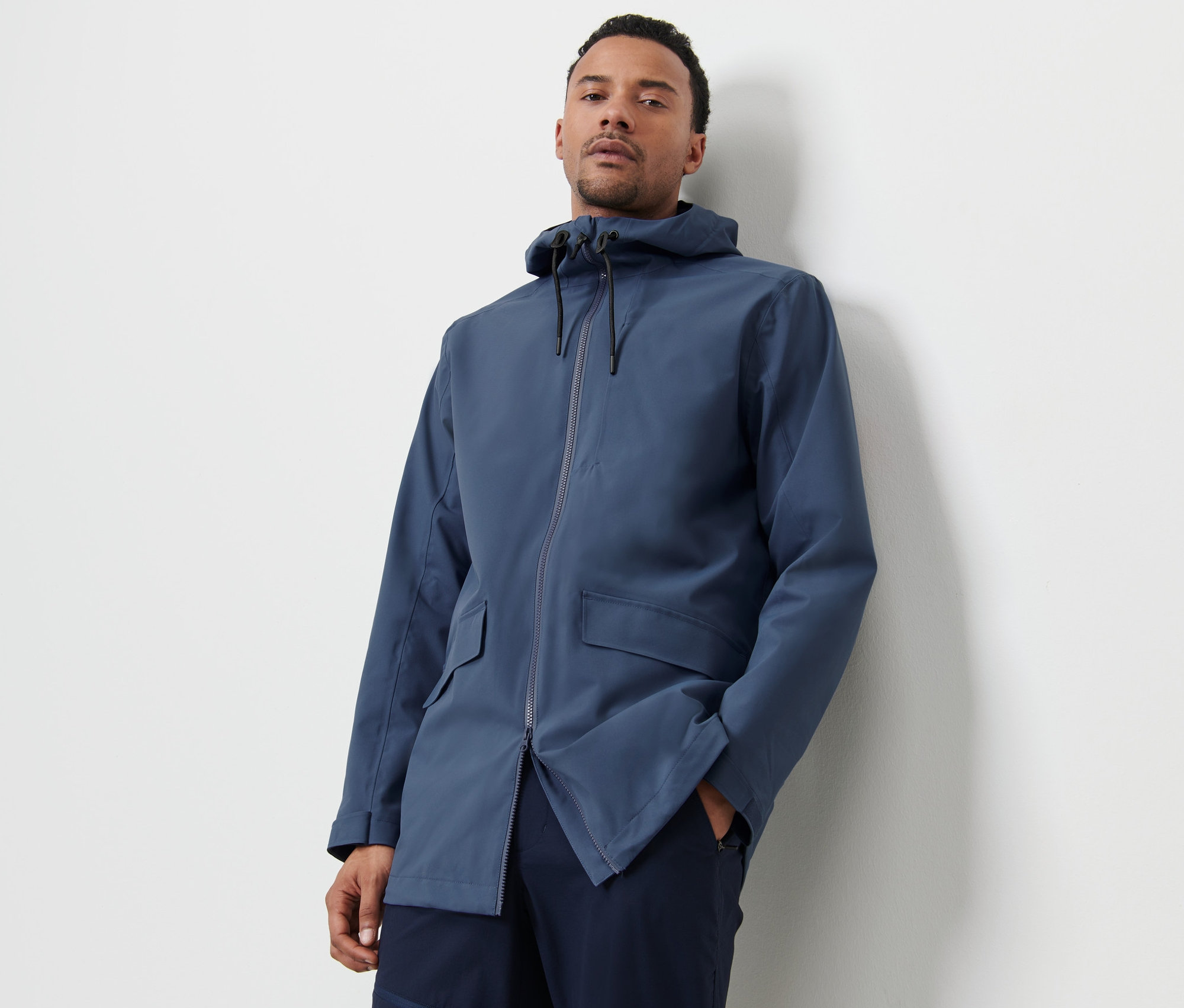 Mężczyzna pozuje w niebieskiej kurtce outdoorowej.