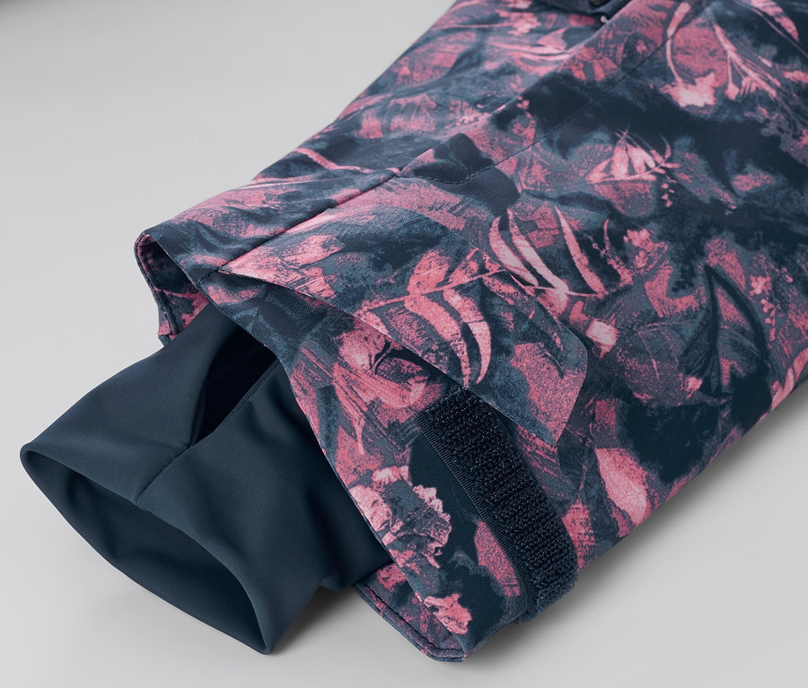 Szczegół rękawa kurtki narciarskiej z krótkim zamkiem błyskawicznym i nadrukiem na całej powierzchni.