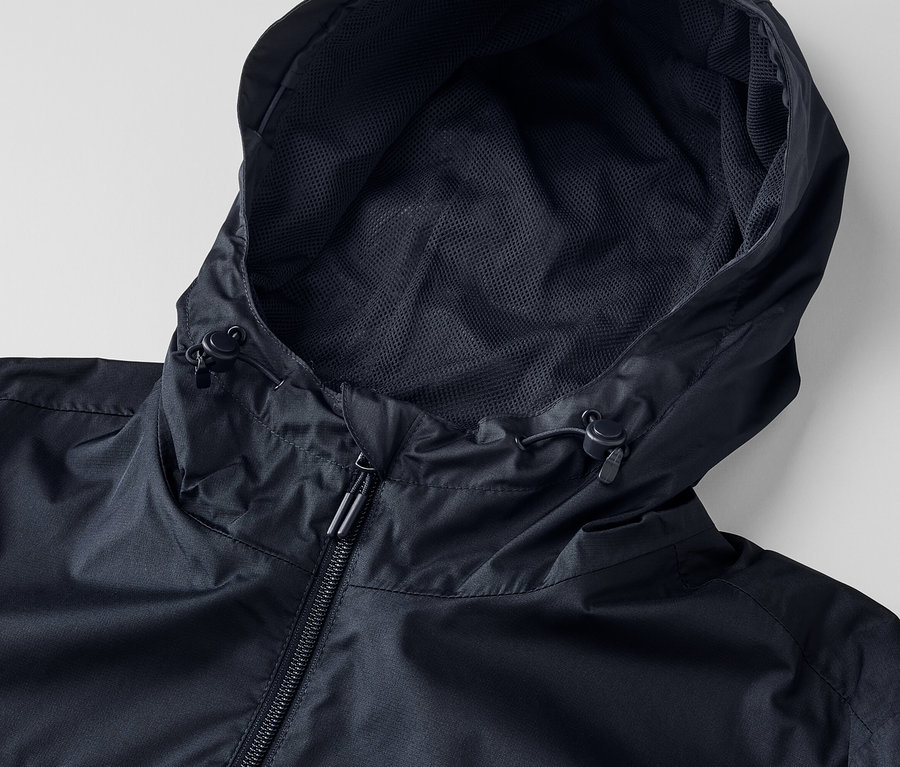 Zbliżenie na czarną kurtkę przeciwdeszczową unisex z kapturem i zamkiem błyskawicznym.