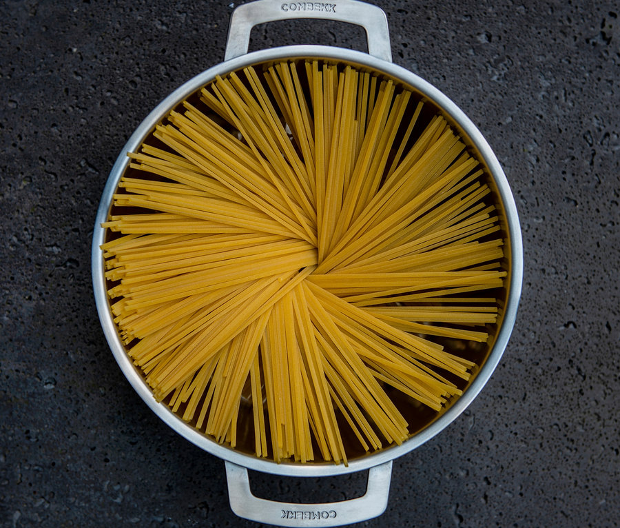 Widok z góry na zestaw garnków ze stali nierdzewnej COMBEKK z ugotowanym spaghetti.