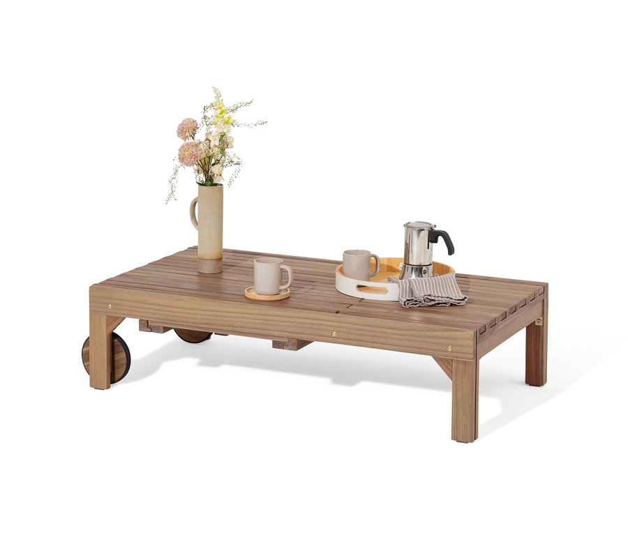 Na drewnianym stole stoi wazon z kwiatami, dwa kubki i ekspres do kawy.