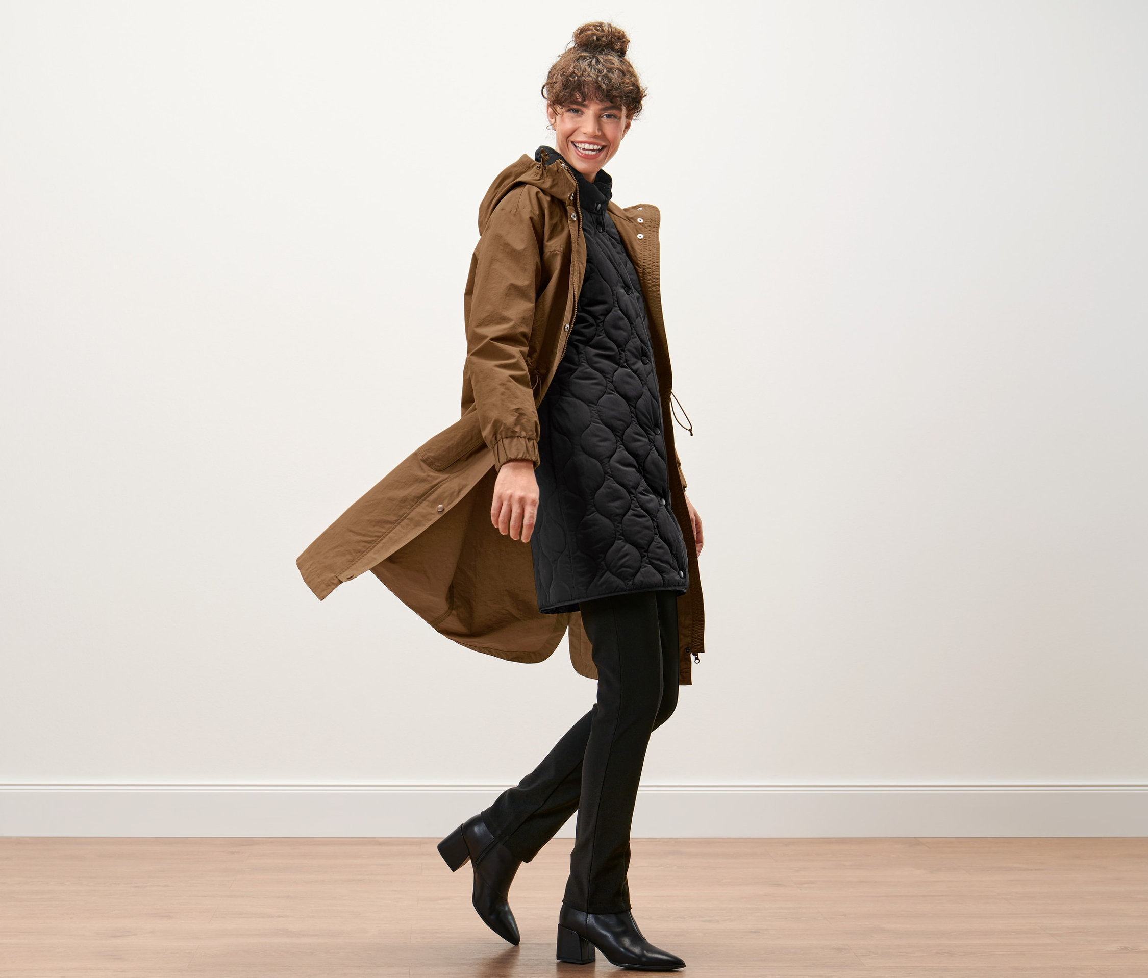 Kobieta idzie i ma na sobie parkę z kamizelką.