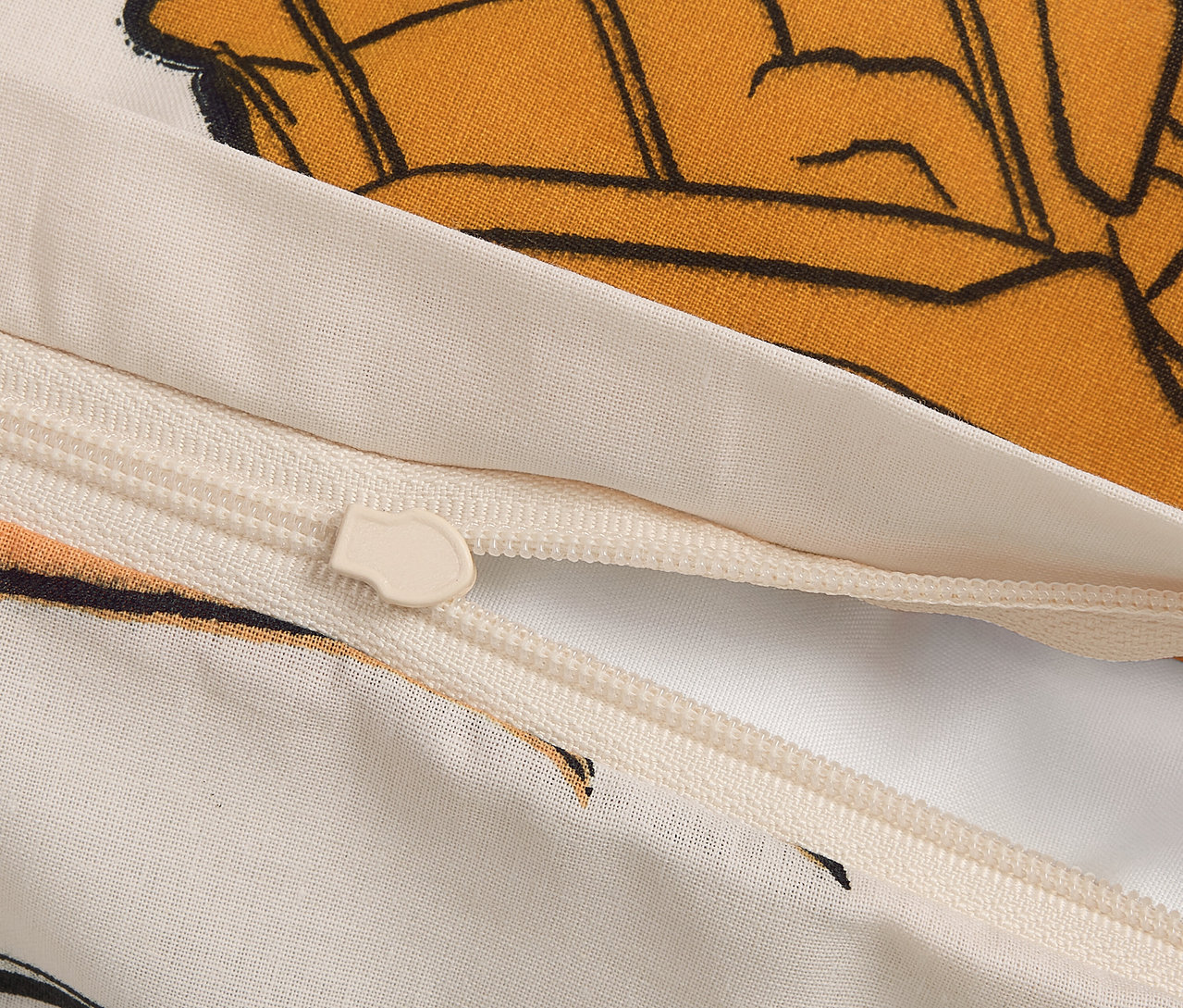 Zbliżenie zamka błyskawicznego na poszewce z motywem z kreskówki.