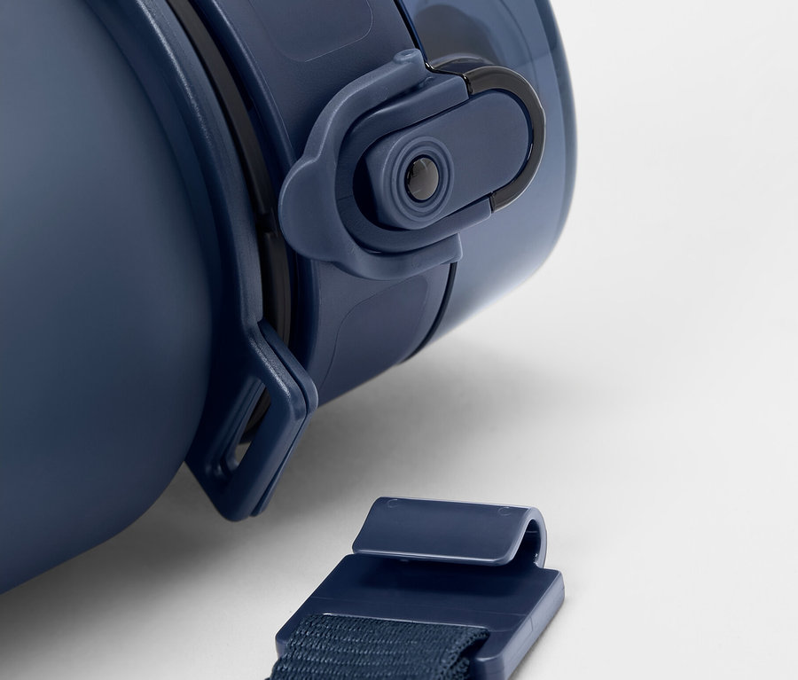 Szczegół niebieskiej butelki z paskiem na białym tle.