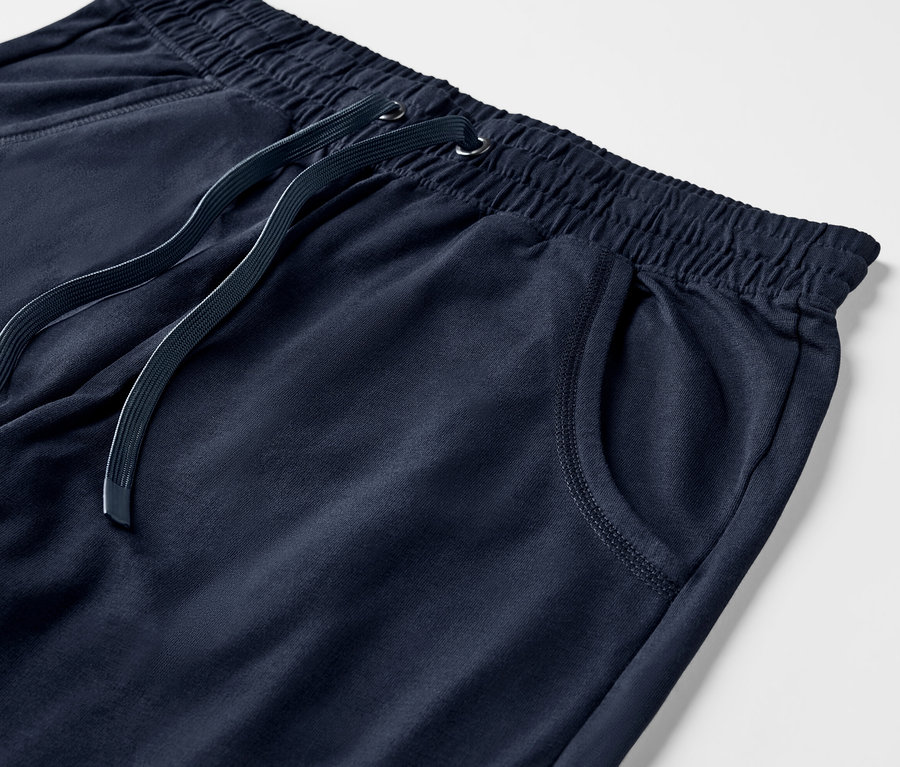 Szczegółowy widok granatowych spodni dresowych o długości 3/4 z elastycznym pasem i sznurkiem.