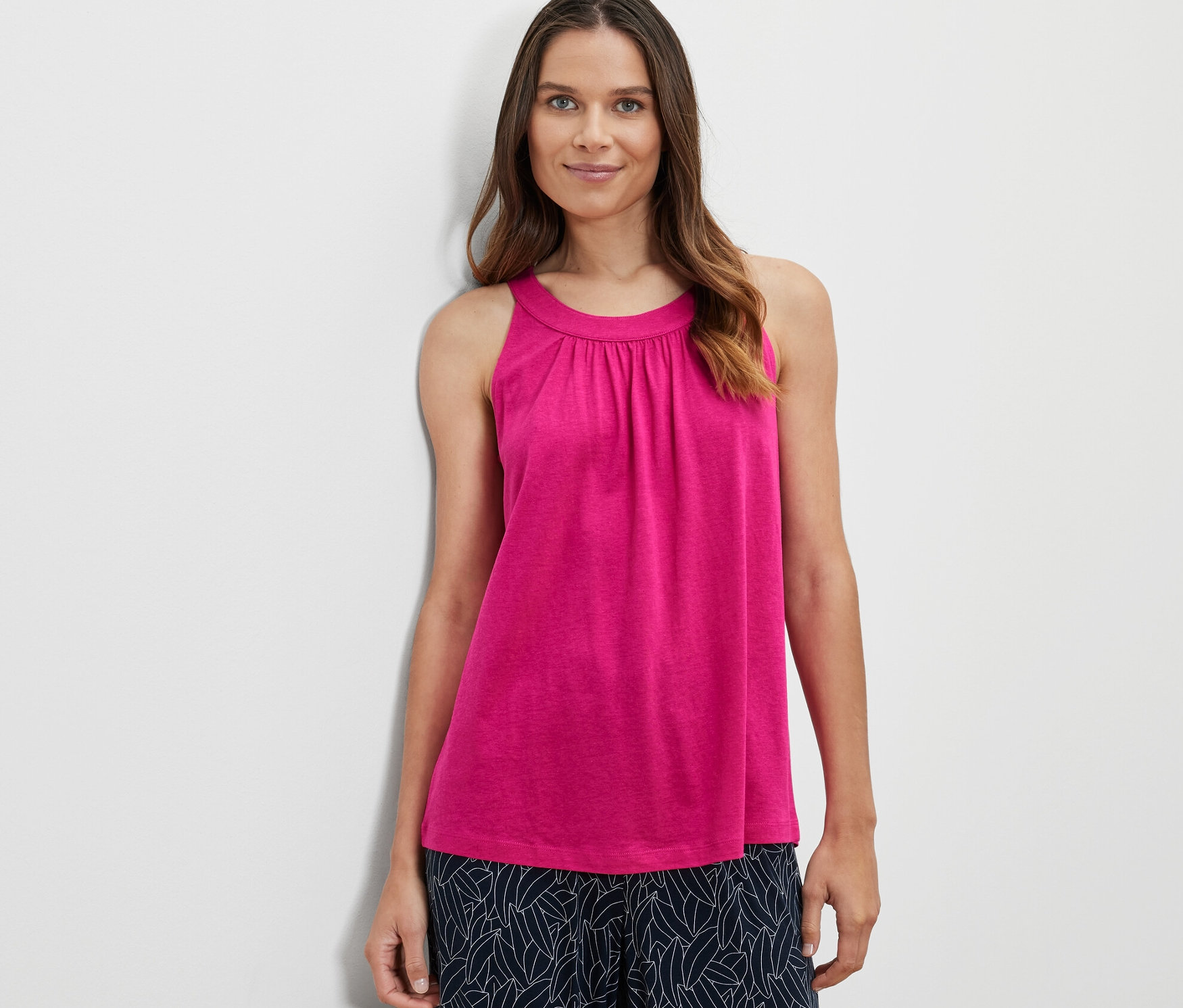 Kobieta ma na sobie różowy top.