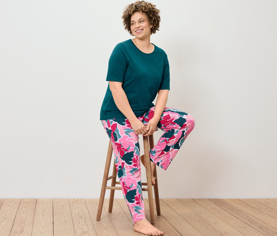 Kobieta siedzi na stołku w piżamie.