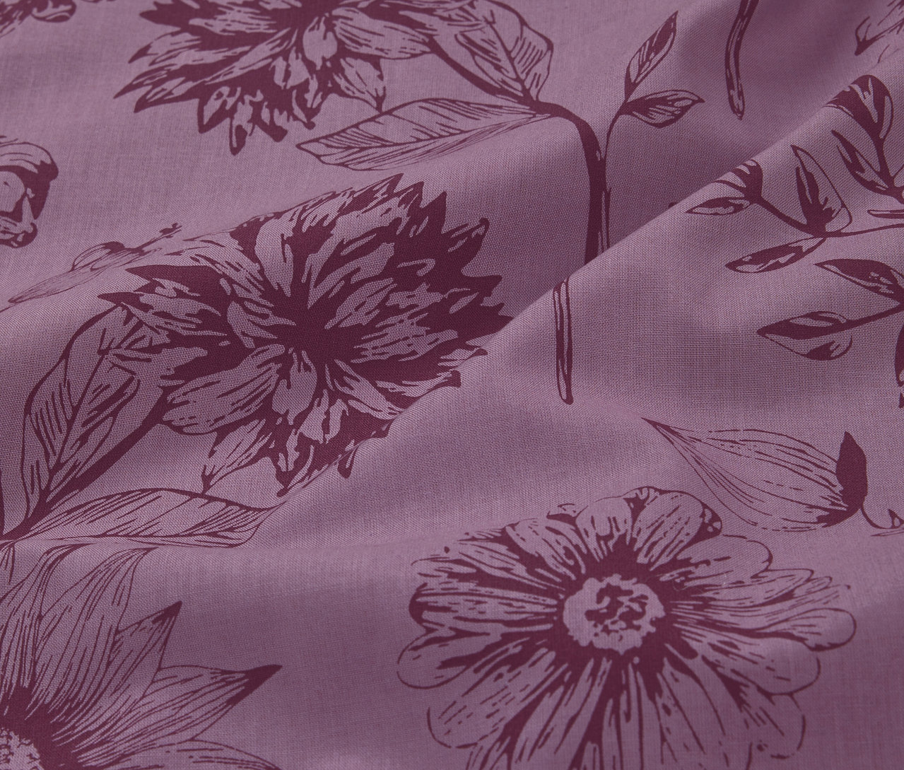 Zbliżenie na fioletową pościel z bawełny renforcé w standardowym rozmiarze, z kwiatowym wzorem.