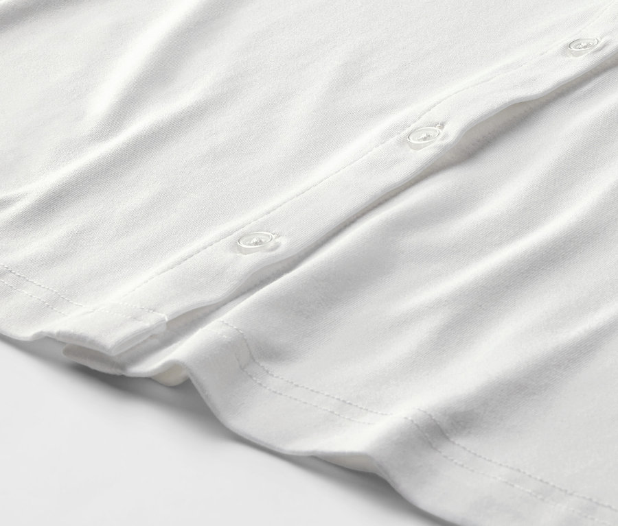 Zbliżenie na białą bluzkę zapinaną na guziki.