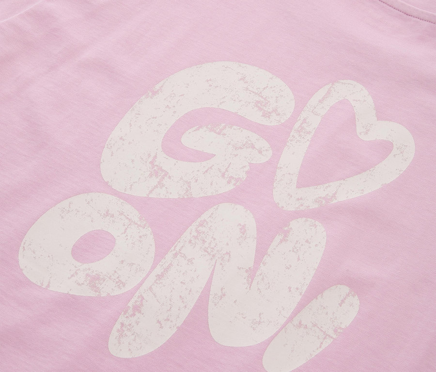 Szczegółowy widok różowej koszulki z napisem "Go On!"