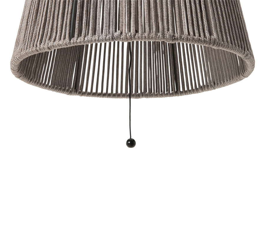 Zbliżenie szarego abażuru z sznurkiem i czarną kulką na końcu.