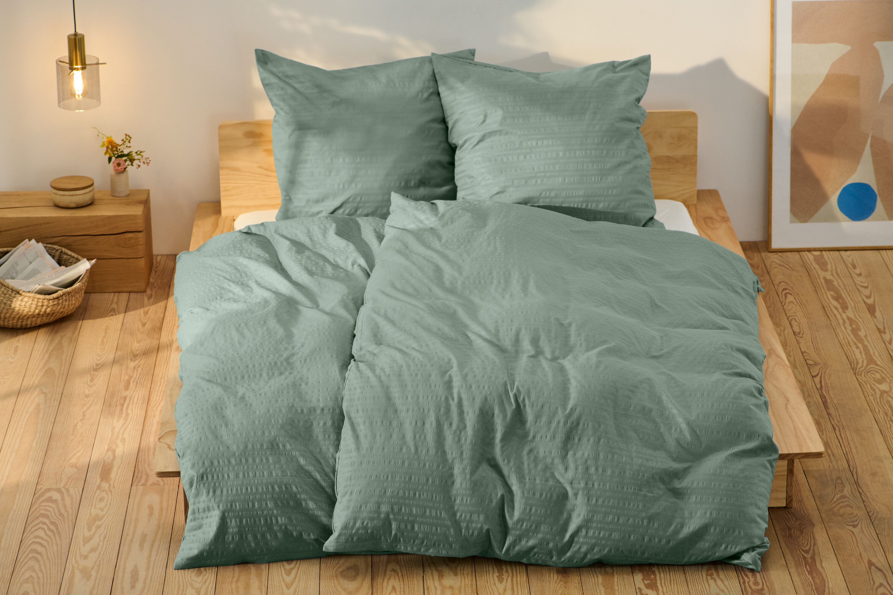 Zielona pościel z kory w standardowym rozmiarze i jedna w rozmiarze niestandardowym na łóżku.