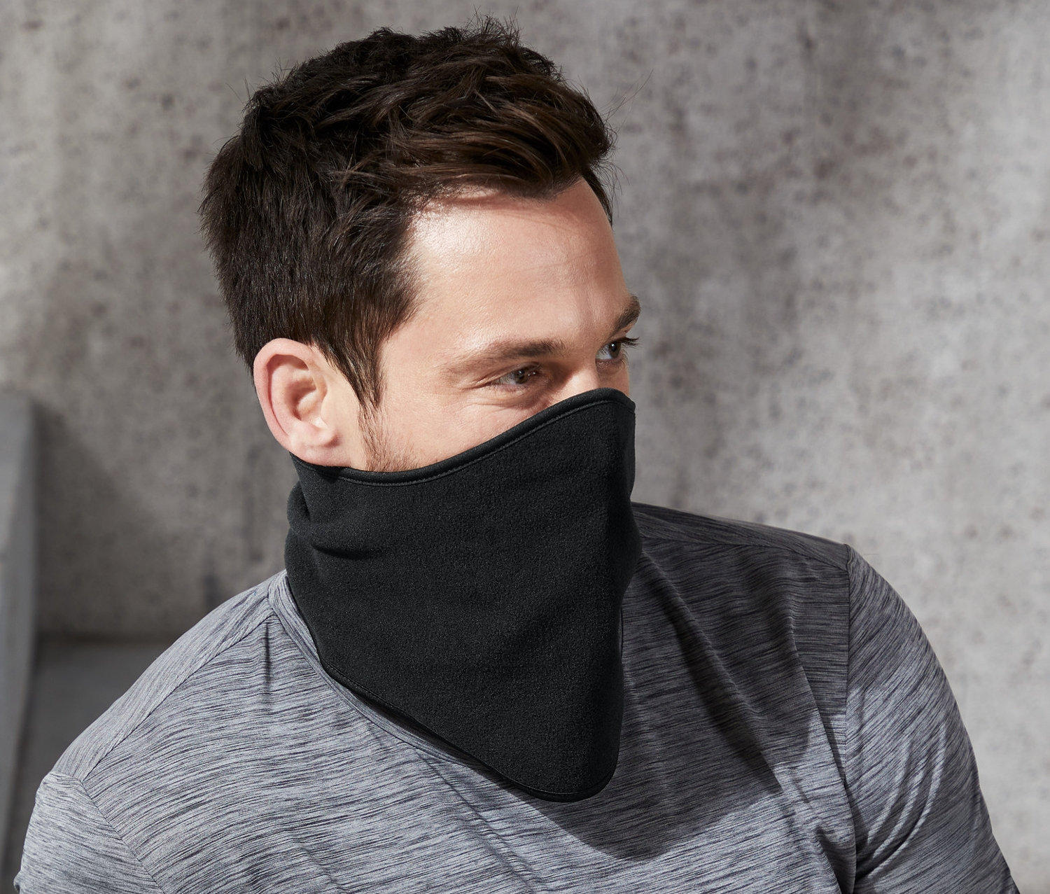 Mężczyzna siedzi w czarnym szal-kołnierzu polarowym.