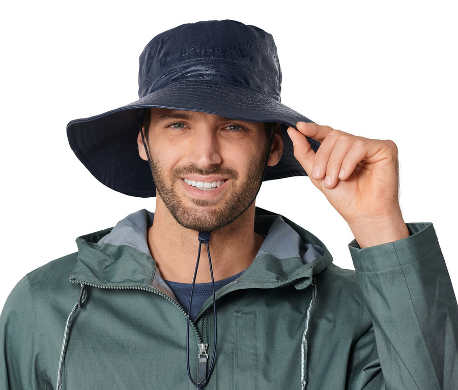 Uśmiechnięty mężczyzna trzyma rondo kapelusza przeciwdeszczowego unisex.