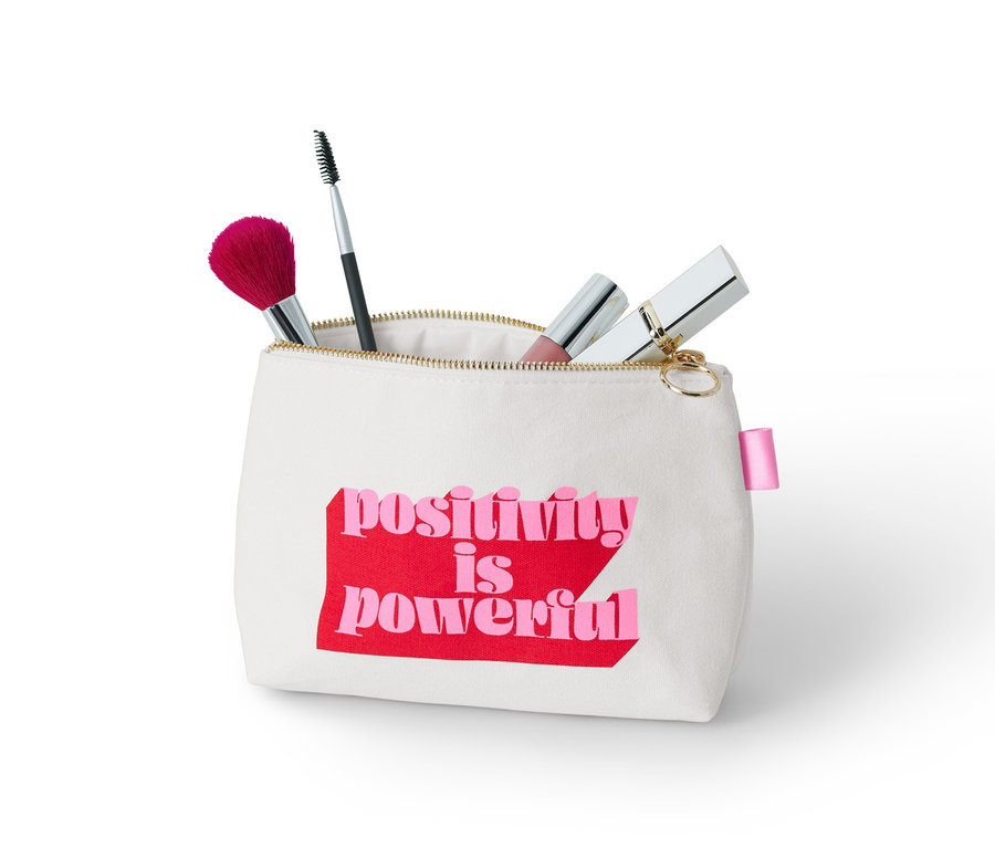 Kosmetyczka z napisem "positivity is powerful" i pędzlami do makijażu.