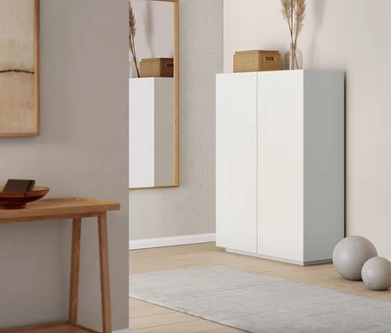 Lustro ścienne i szafa typu highboard we wnętrzu. Konsola z 2 półkami widoczna po lewej stronie.