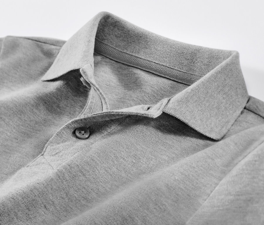 Zbliżenie na szarą koszulkę polo z bawełny piqué dla dzieci.