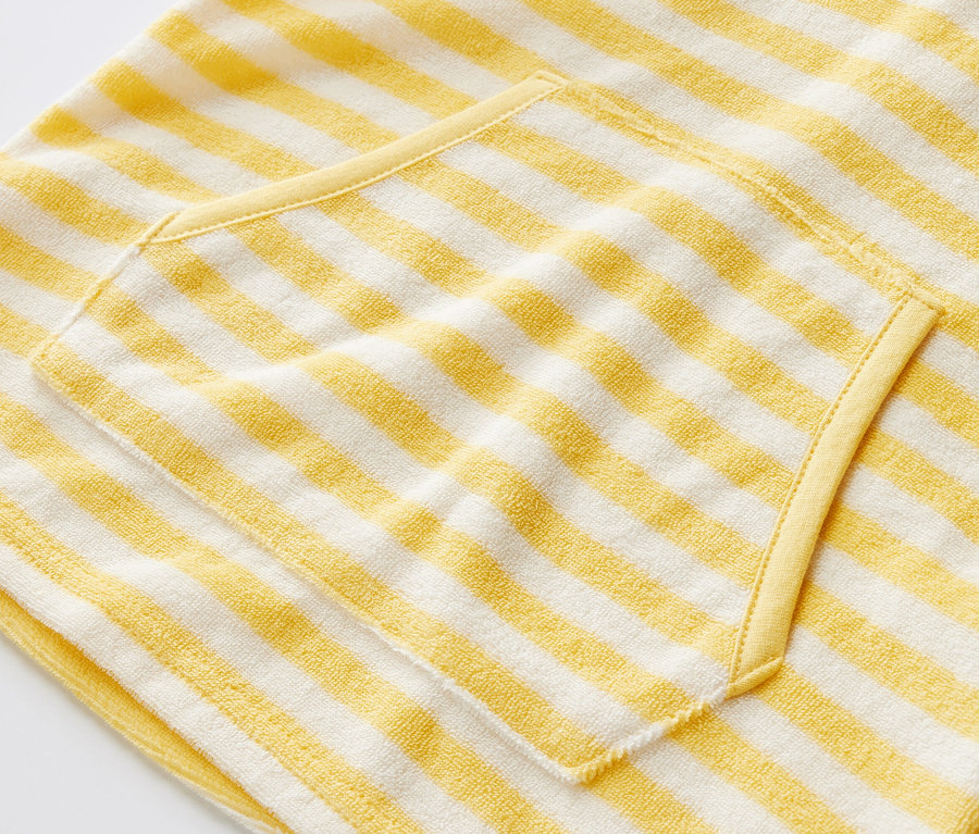 Zbliżenie na ponczo z tkaniny frotté w paski dla dzieci z kieszenią.